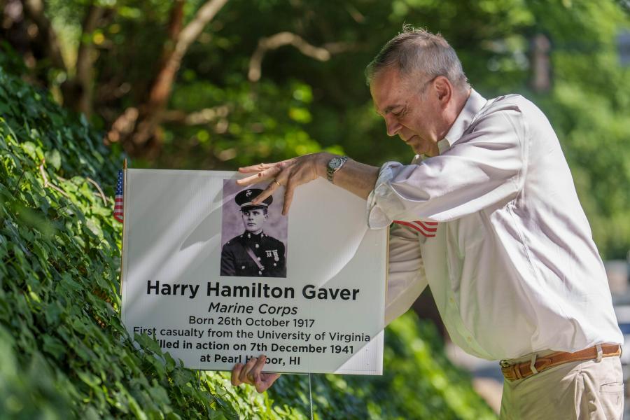 Greg Saathoff placing a yard sign about Harry Hamilton Gaver
