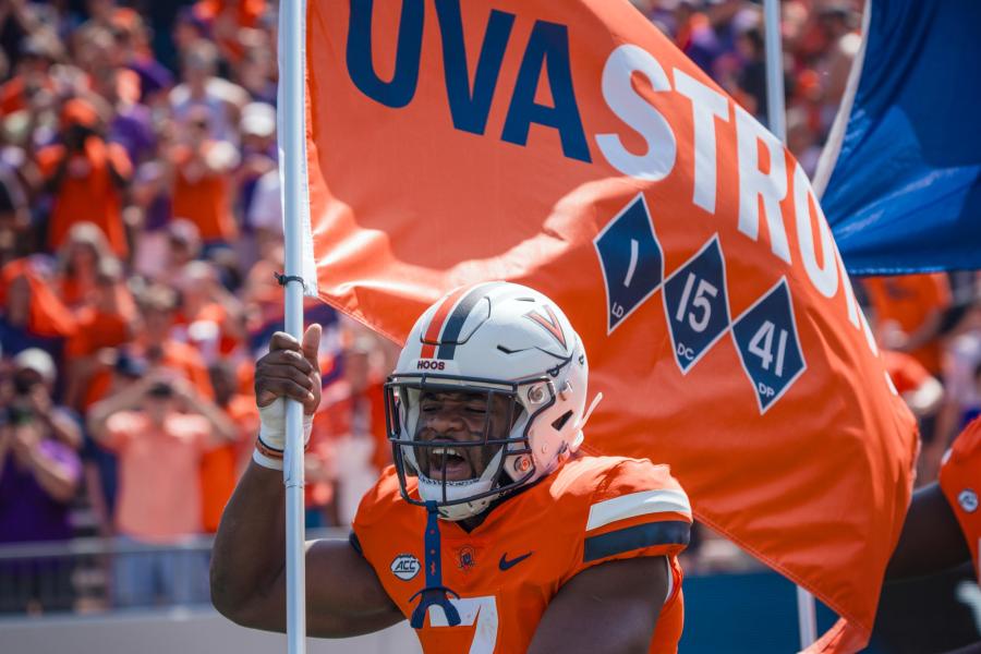 Candid portrait of Mike Hollins carrying the UVA Strong flag during the match day.y