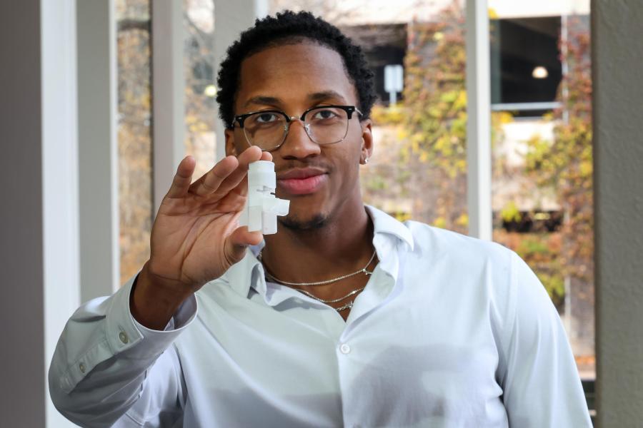 Miles Lanham holding out an example of his medical rescue device.