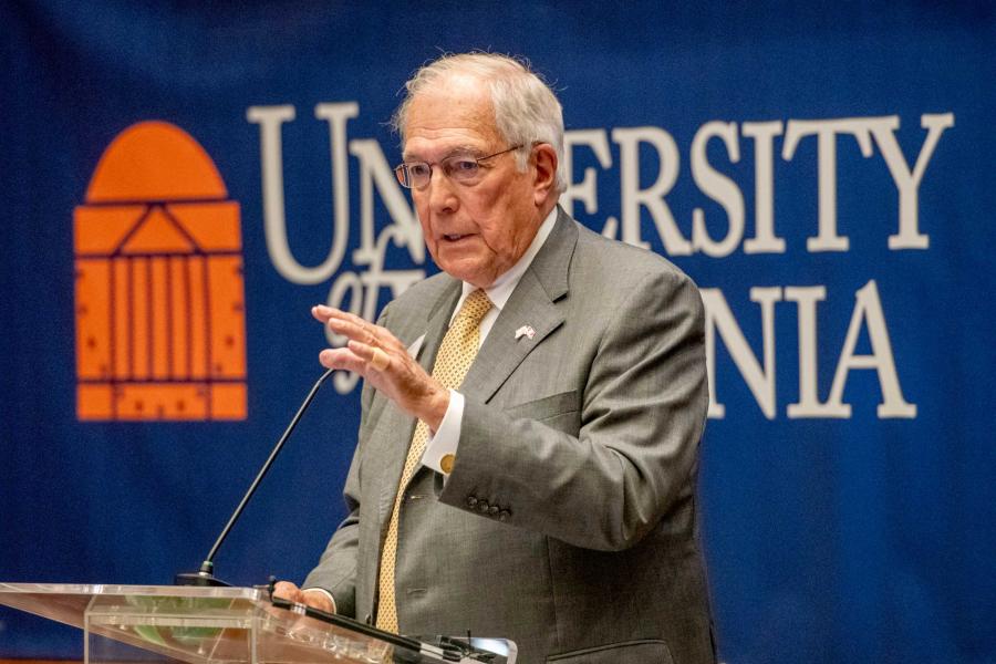 Candid Portrait of John Nau speaking to a group of College of Arts & Sciences faculty at a ceremony.