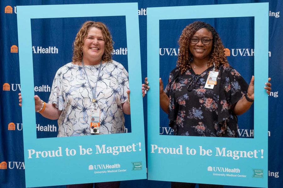 Shari Stanley, left, a nursing governance clinical leader, celebrates with Laquita Minor, a clinical-care director posing with blue cut outs