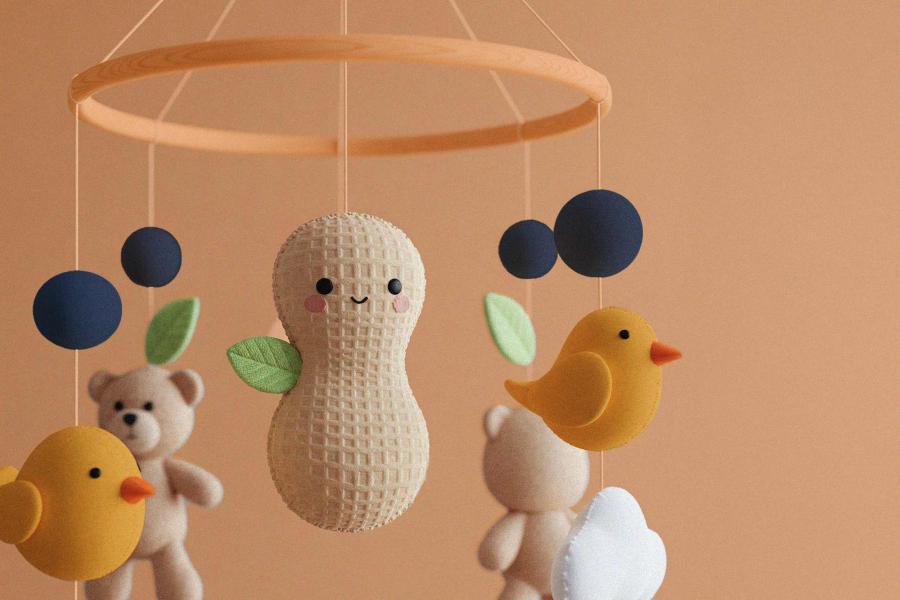Illustration of a baby’s mobile with a stuffed peanut