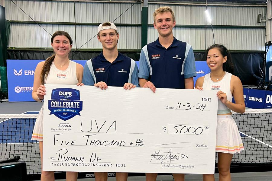 UVA students, from left to right, Alexandra McDonald, Eli Mautner, Conor Burns and Vivianne Ngo holding a large check together 