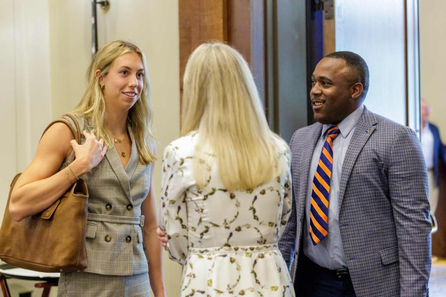 Candid of Gretchen Walsh, Rachel Sheridan and Quana Dennis talking at the Board of Visitors’ meeting