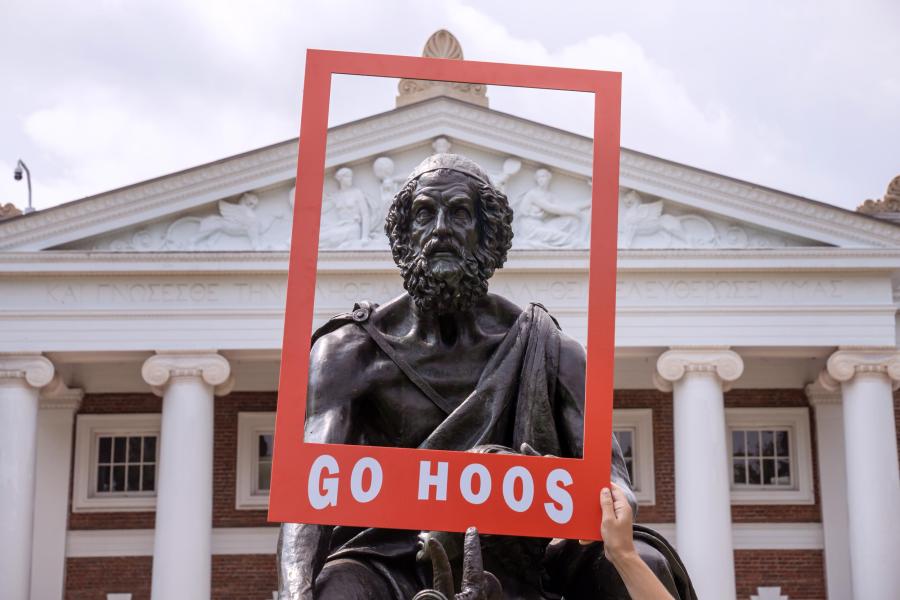 Portrait of the UVA Homer Statue in a portable red paper frame with 'Go Hoos' written on it.