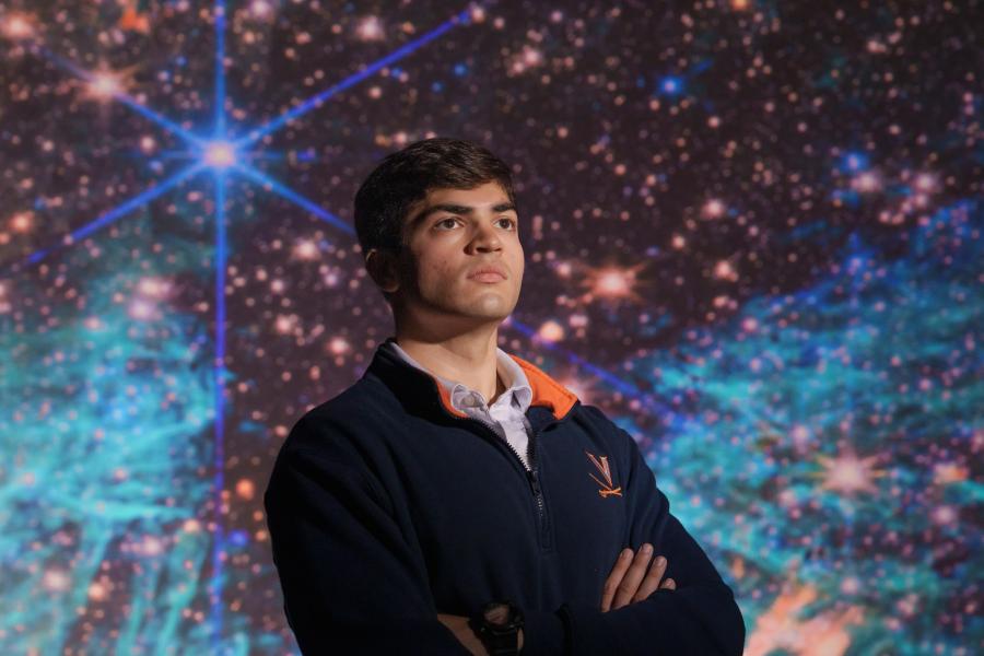 Portrait of Sam Crowe in front of a digital display of deep space