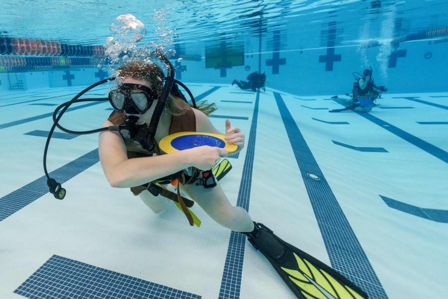 Elizabeth Armstrong throwing a frisbee underwater