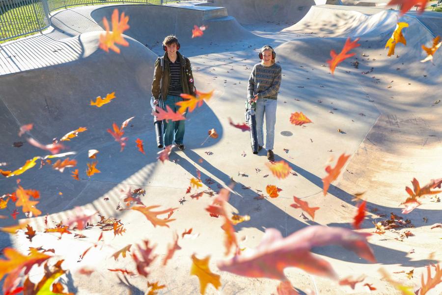 Jack Ellis and Jillian Fletcher stand in a skate park bowl that they are using leaf blowers to clear.