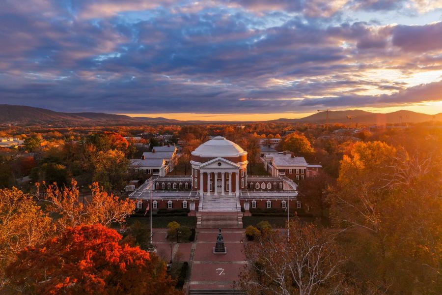 the UVA Rotunda at sunset surrounded by fall foliage.