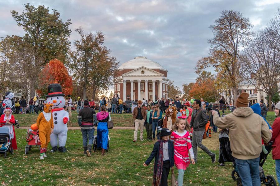 A portrait of kids and parents in various costumes during the Trick-or-Treating event on the University of Virginia's Lawn, with the Rotunda in the background.