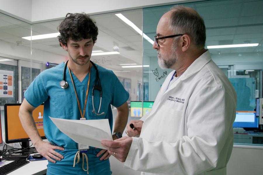 Candid shot of Dr. William Brady speaking to a nurse