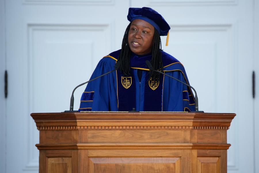 Claudrena Harold, in blue and black robes, speaks from a podium to the UVA Class of 2022