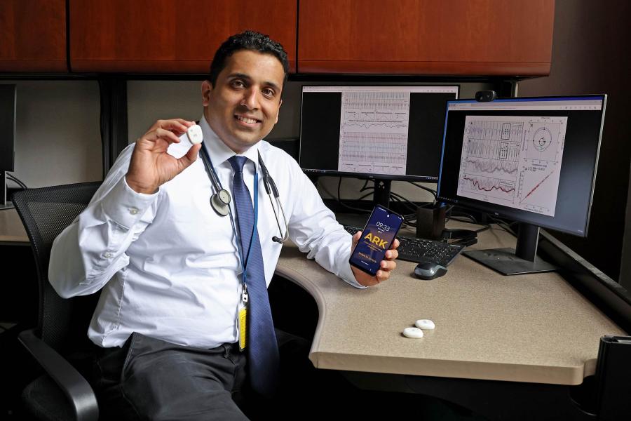 Dr. Shrirang Gadrey holding his device and phone up to show how it operates