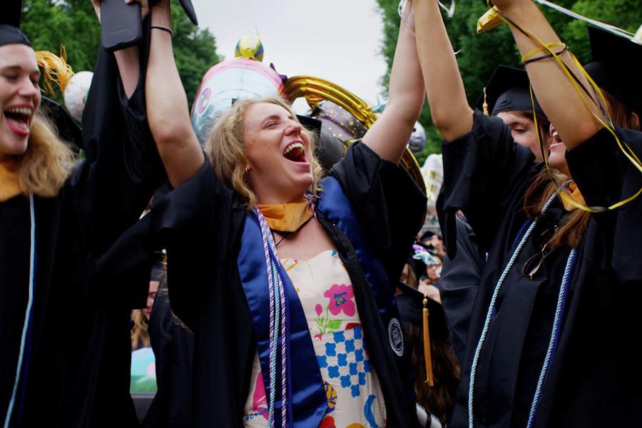 Graduates put their hands up in celebration