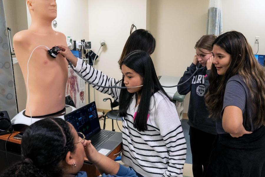 Middle school students learning how to use a stethoscope