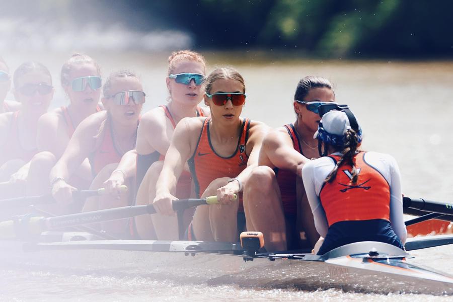 Skylar Dahl, in teal-rimmed sunglasses, with fellow crew mates in the middle of rowing.