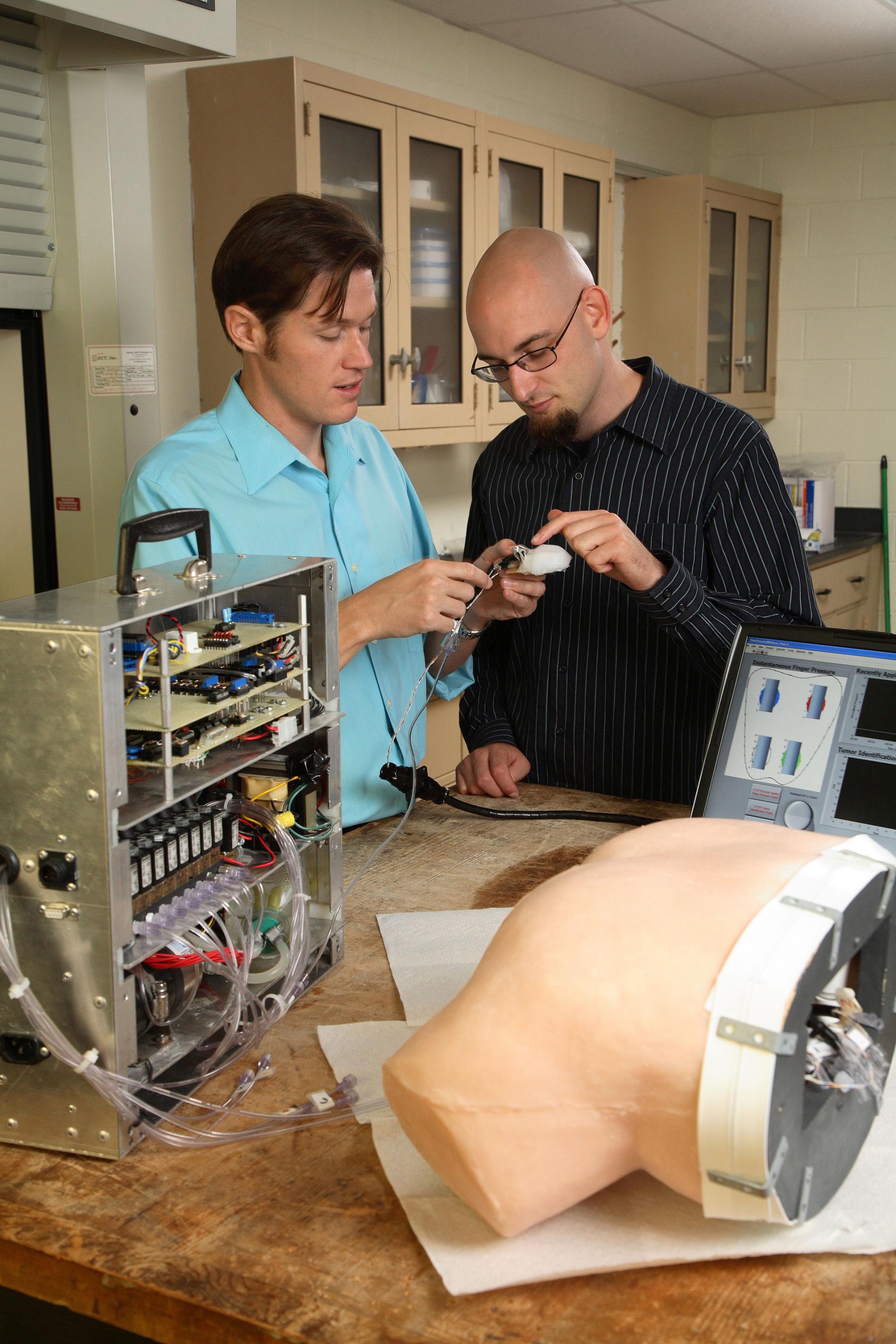 Greg Gerling shows simulator to Ph.D. student Daine Lesniak.(Photo: Tom Cogill)