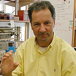 James Landers with an earlier prototype of his "lab on a chip," which could speed DNA testing from days to minutes.