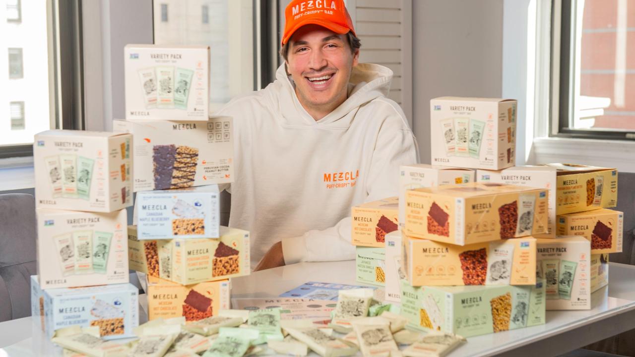 Griffin Spolansky sitting behind a table covered in Mezcla products