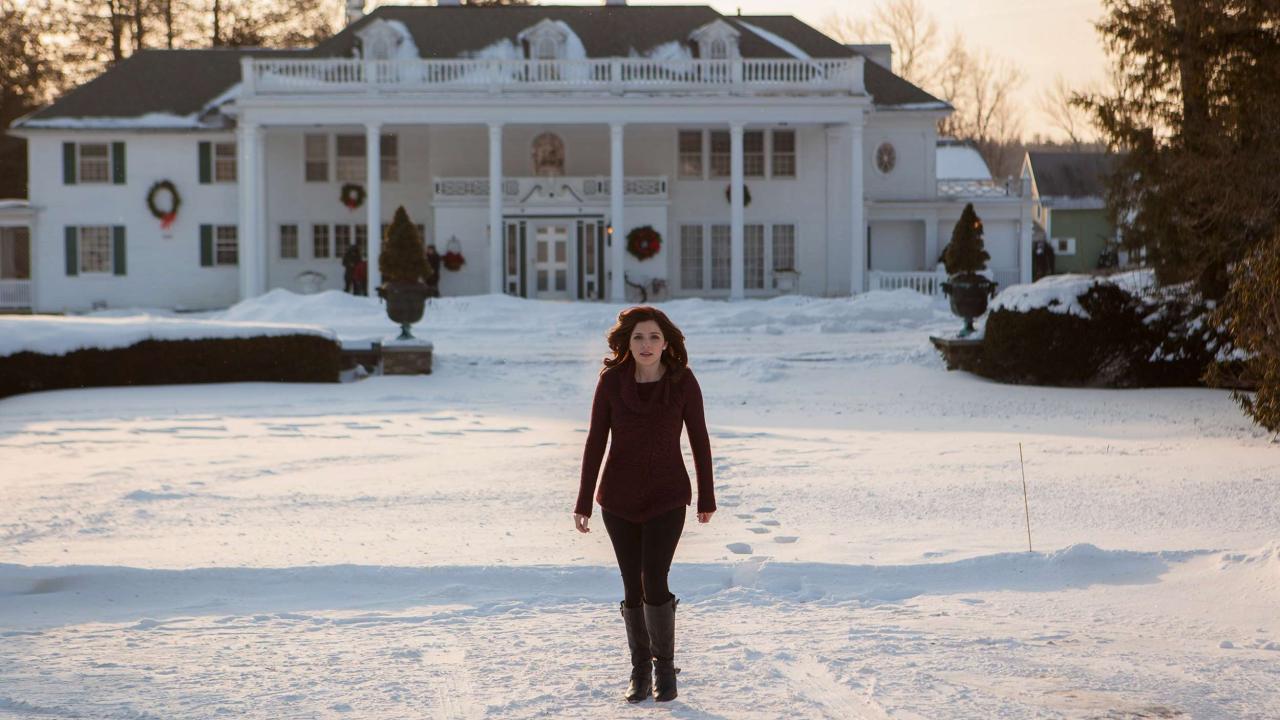 Jen Lilley walking across the snowy ground away from a big house