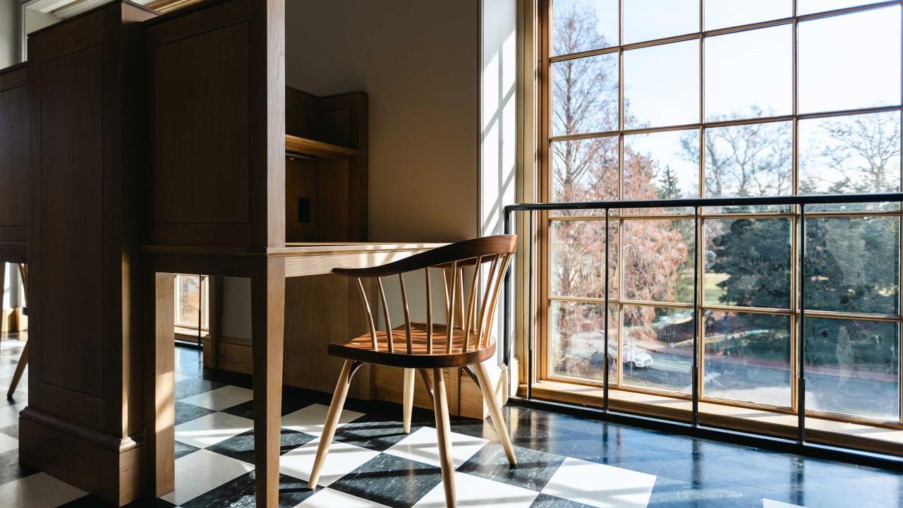 A wooden chair and desk by a window in Alderman