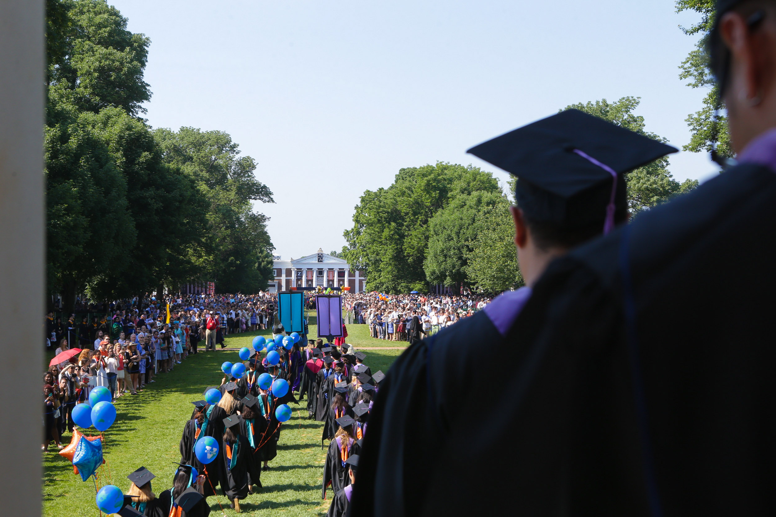 Graduates walking the lawn to their seats