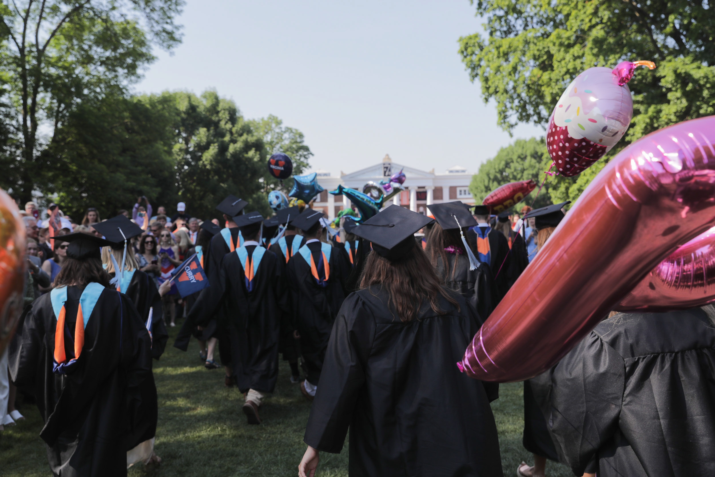 Graduates walking the lawn to their seats