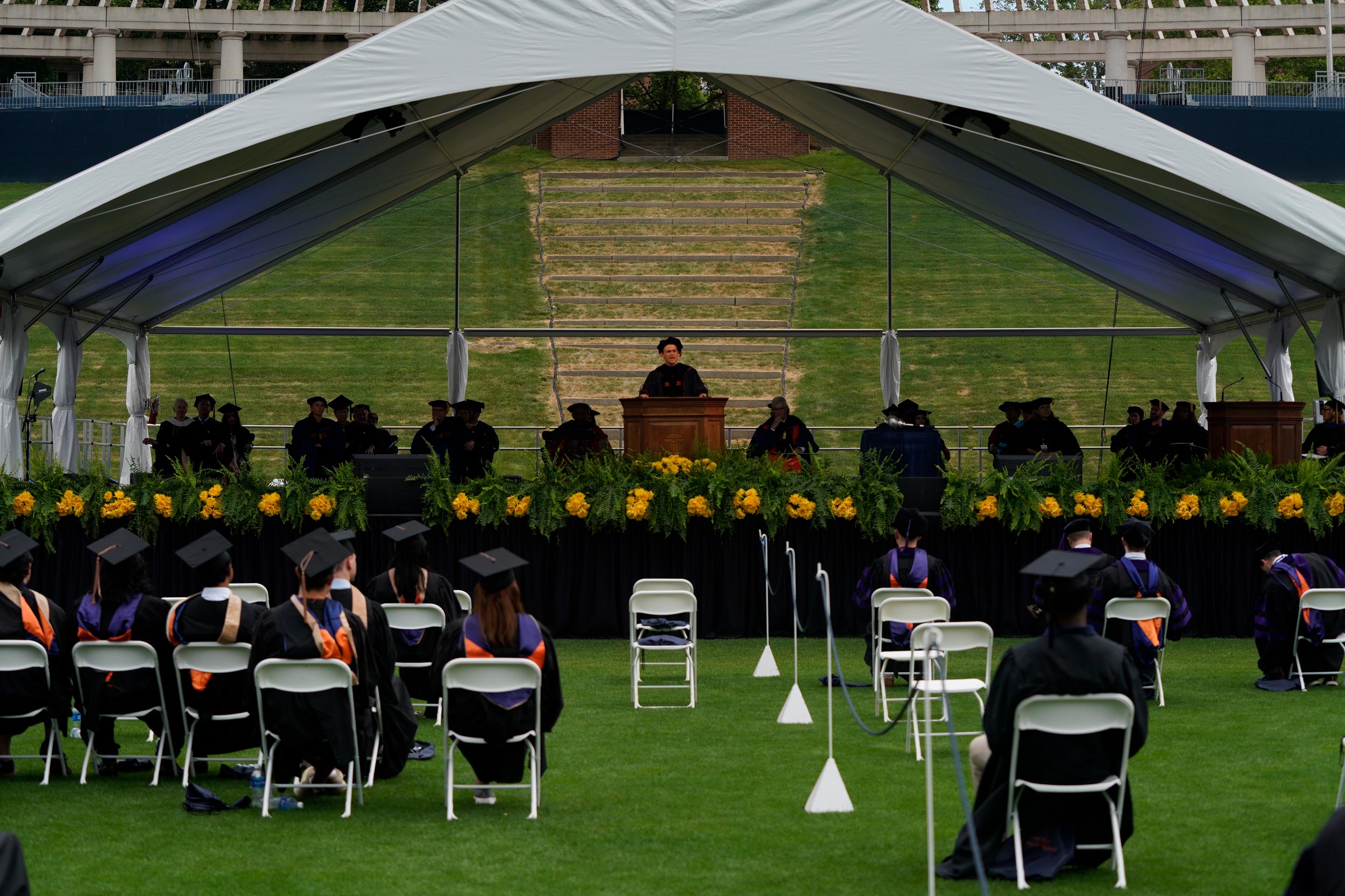 Graduates watching the stage as President Jim Ryan gives a speech