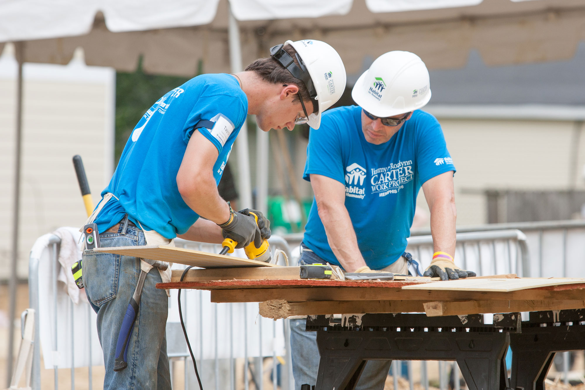 Thompson working with another person to cut a board