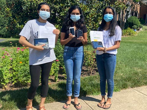 Left to right Anika Iyer, Rachana Subbanna and Tanvi Nallanagula hold tablets, cellphones as they pose for a picture