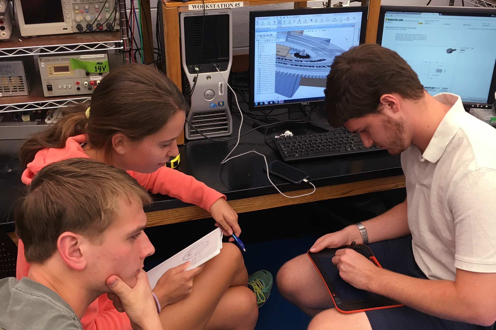 Three students designing a clock on a computer