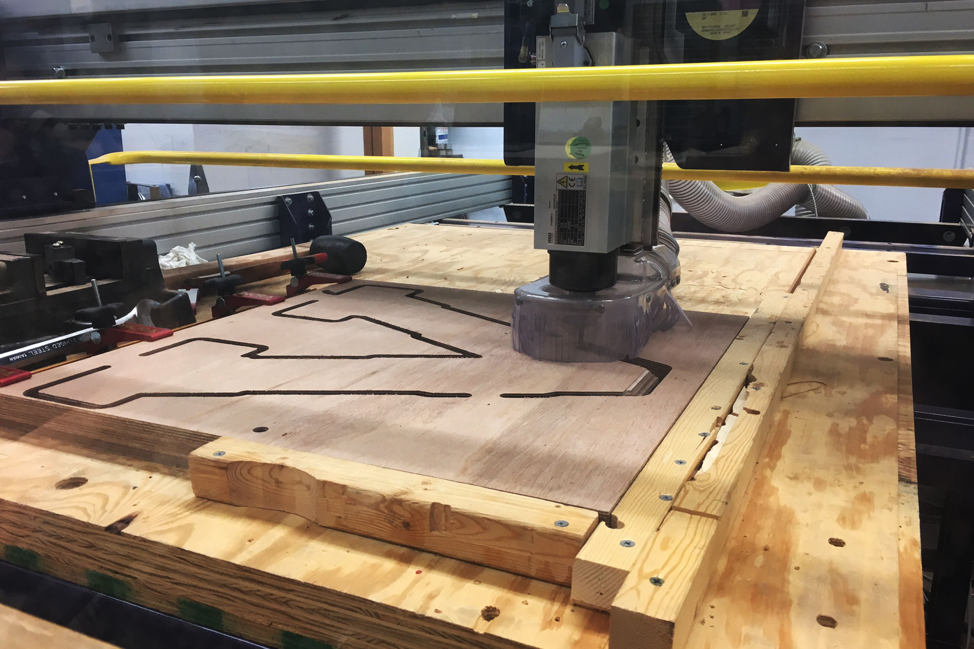 Heavy machinery cutting out a V from a piece of wood