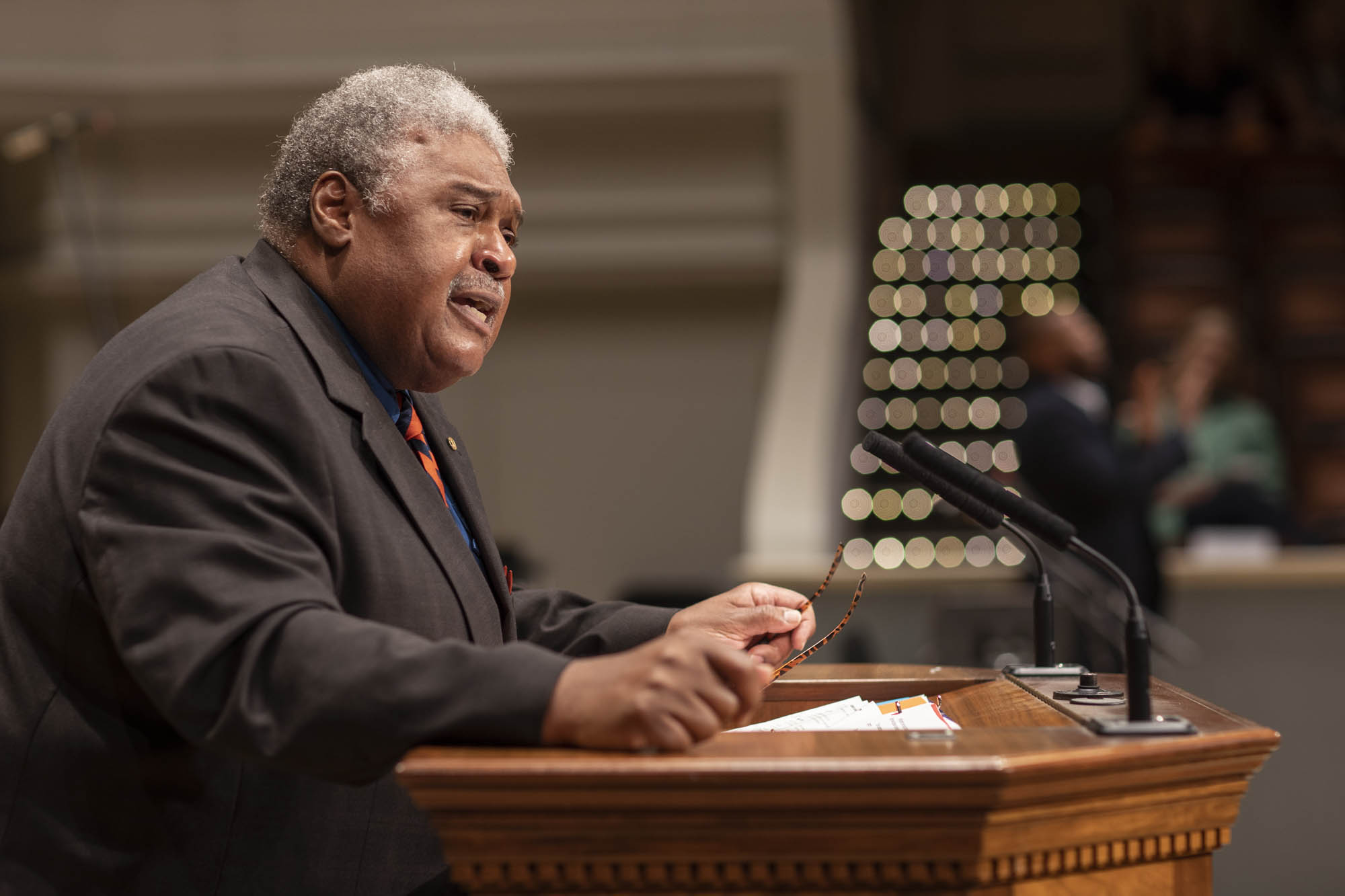 The Honorable John Charles Thomas stands at a podium giving a speech