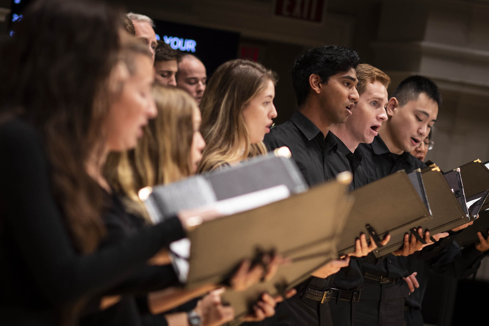 Oratorio Society of Virginia singing with black binders