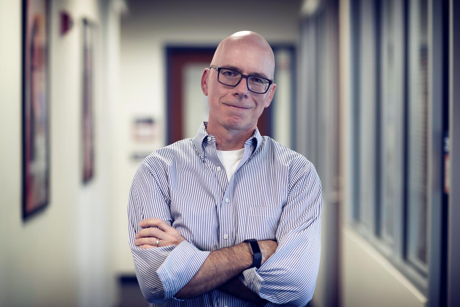 Tim Davis standing facing the camera with his arms crossed