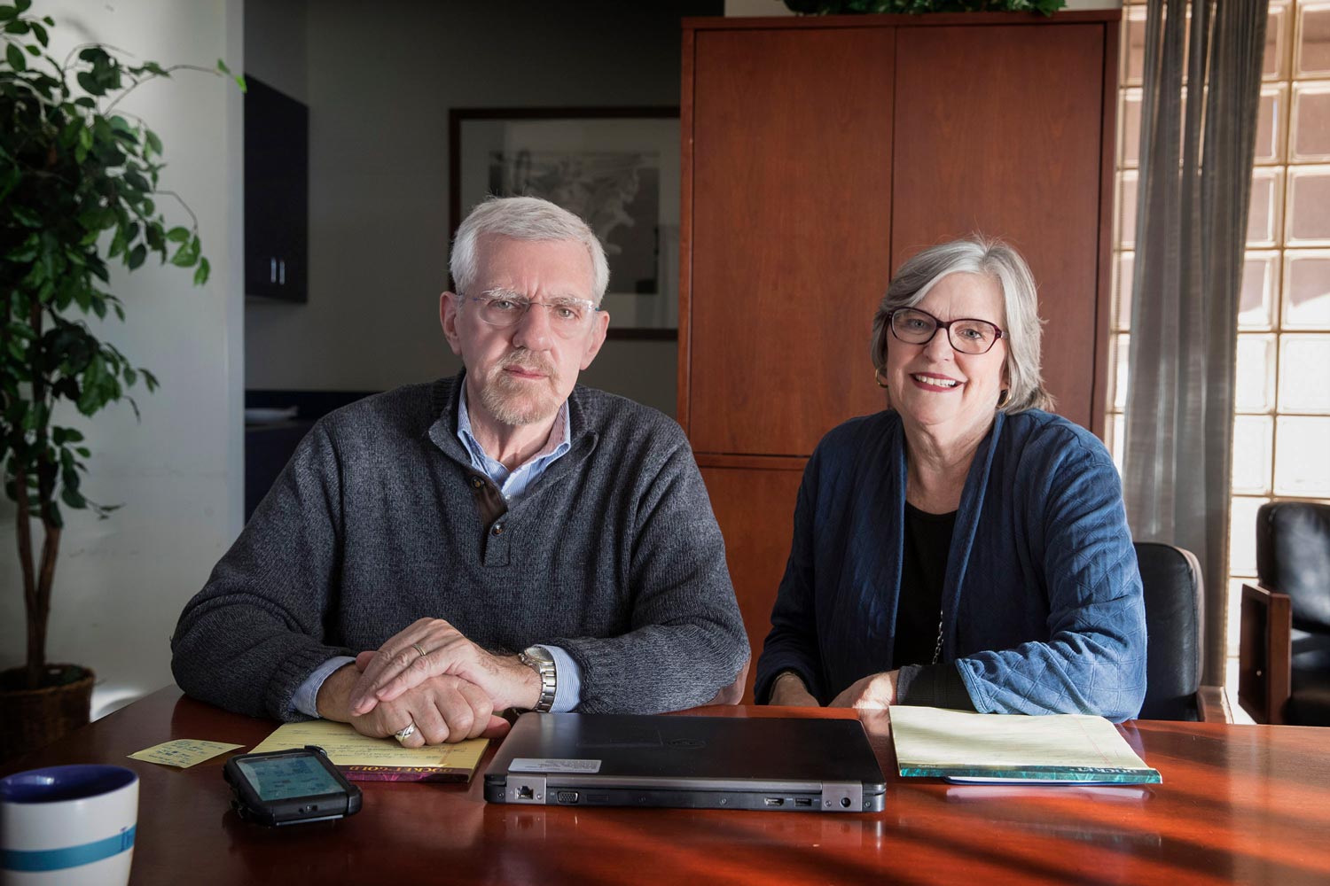 Tom Guterbock and Kate Wood  sit at a table together looking at the camera