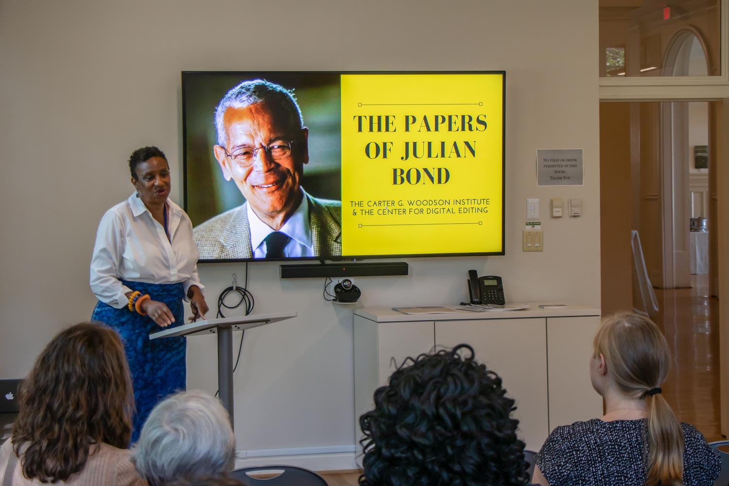 Women in front presenting a Power Point slide to a crowd.  The slide is titled The Papers of Julian Bond