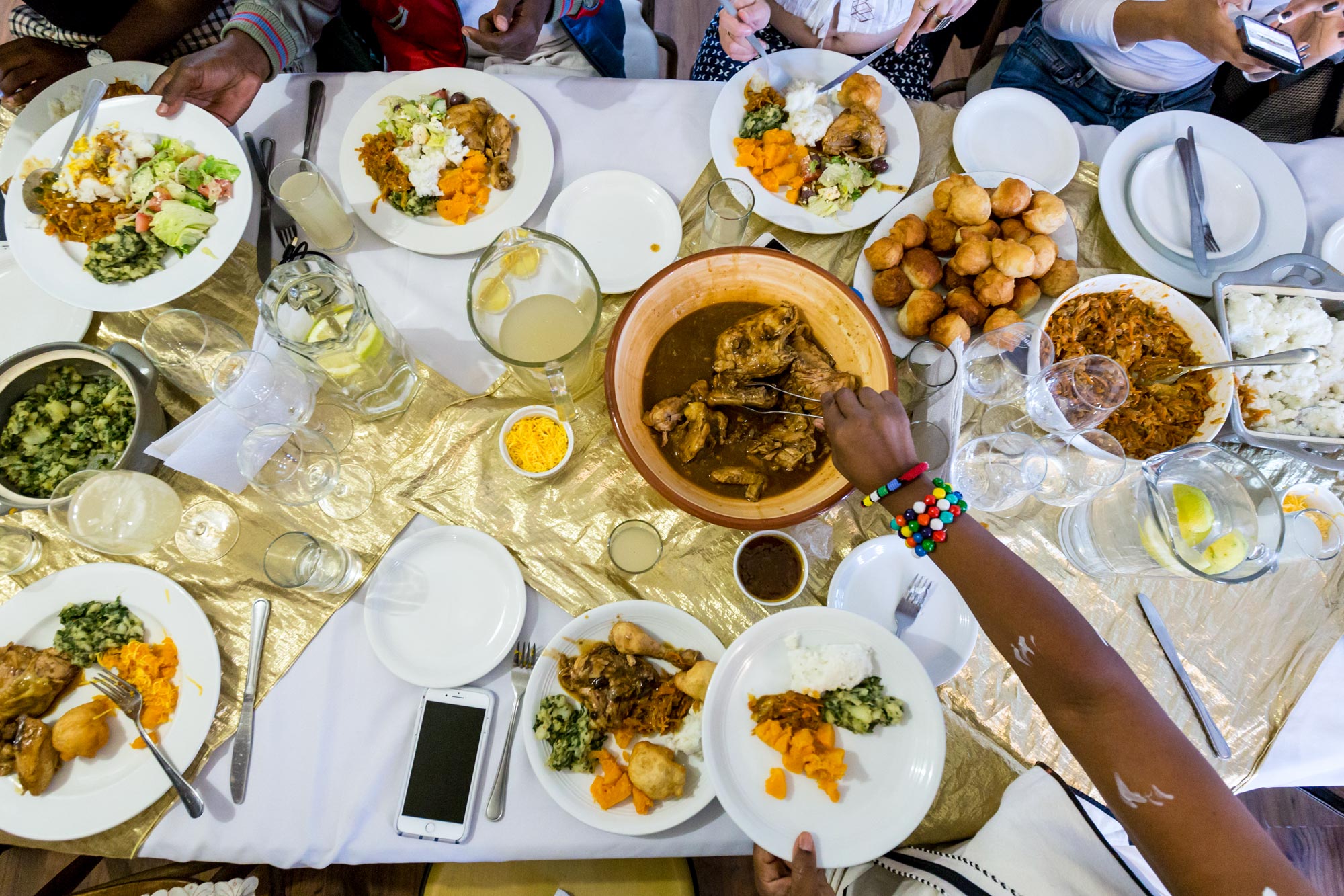 Aerial view of a table full of various food in dishes on peoples plates