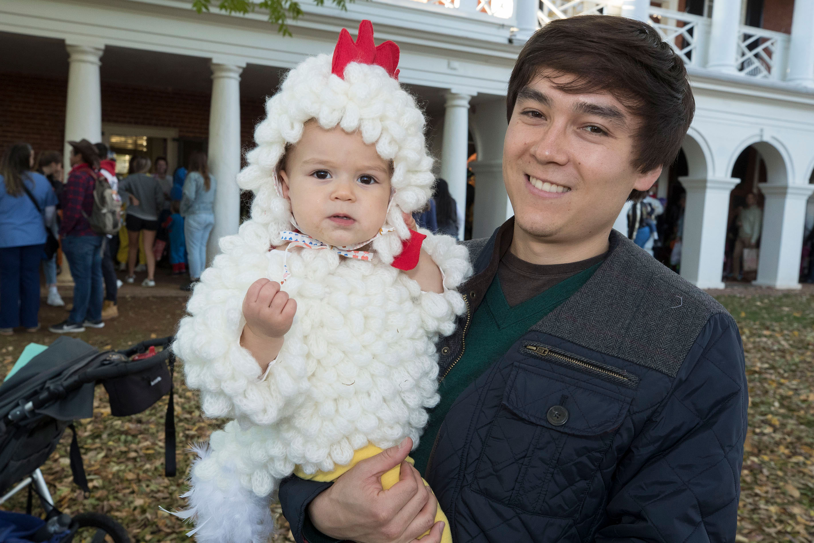 Student holds a baby dressed up as a chicken