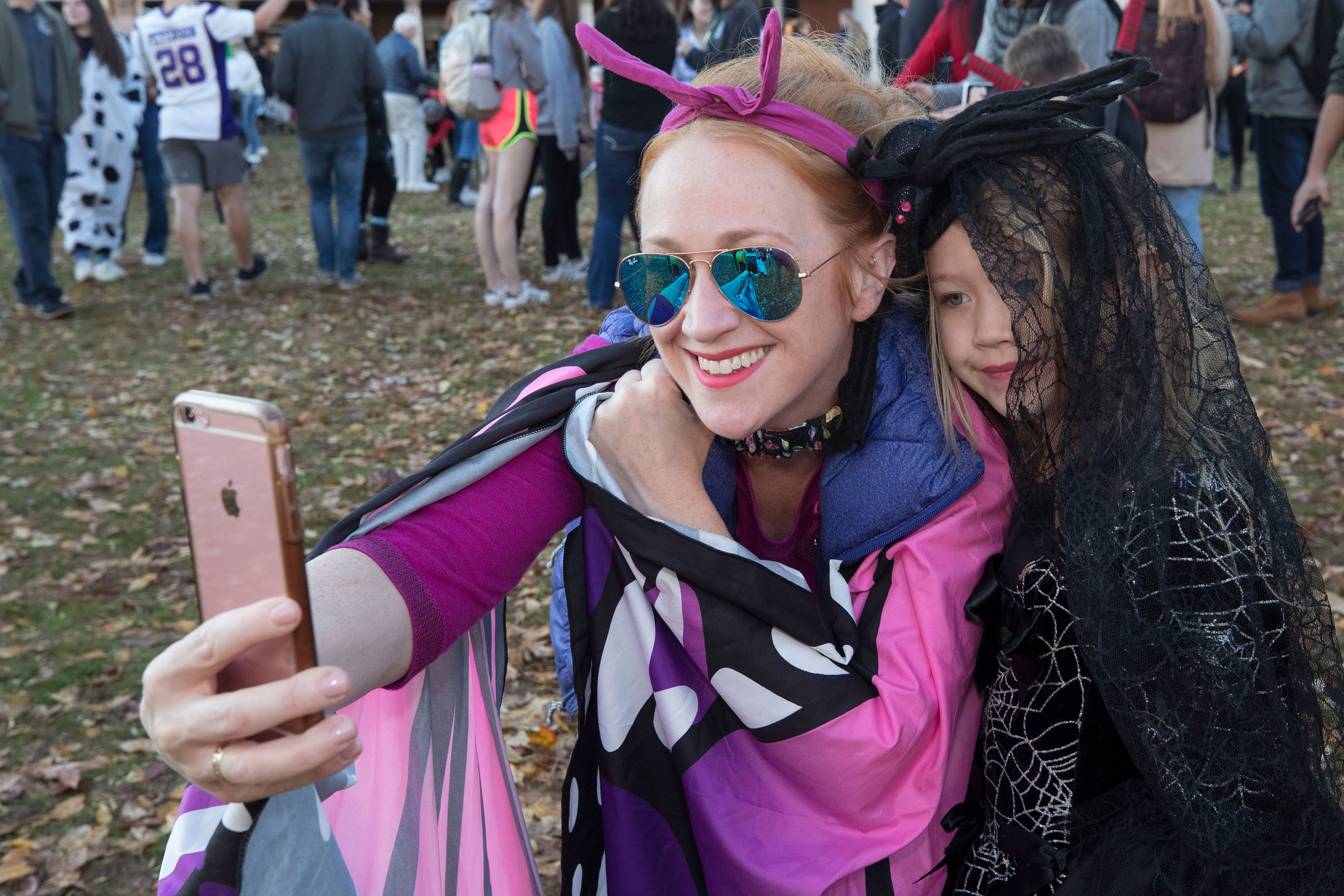 Student taking a selfie with a child dressed in a witches outfit