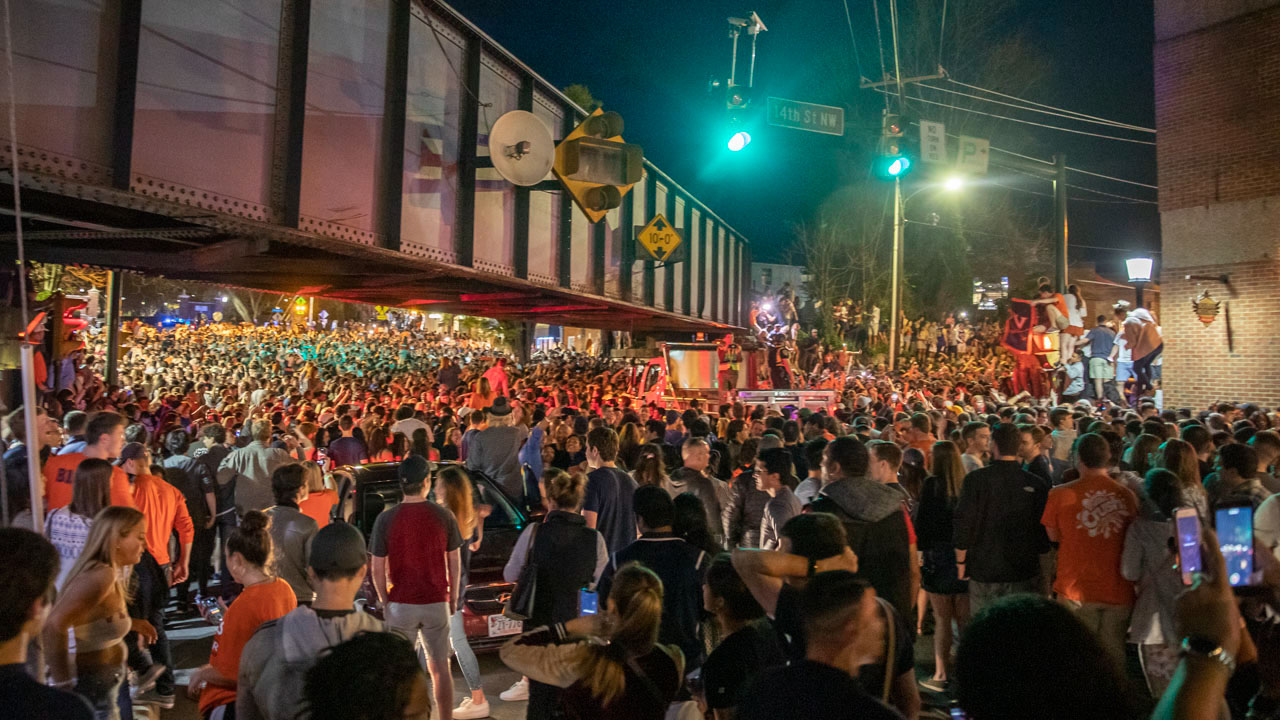 14th street northwest filled with people decked out in orange and carrying homemade UVA signs