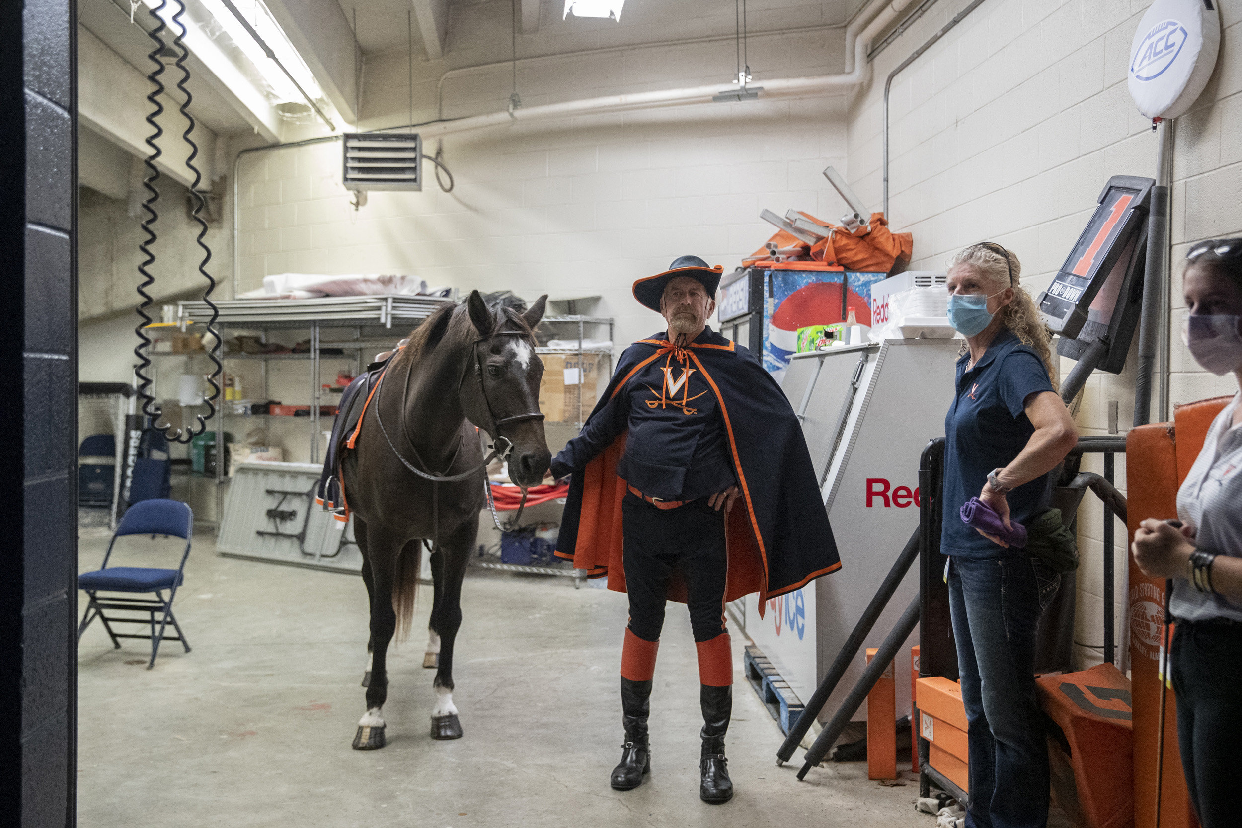 Man dressed in UVA hat, cape and UVA shirt with horse before the Football game