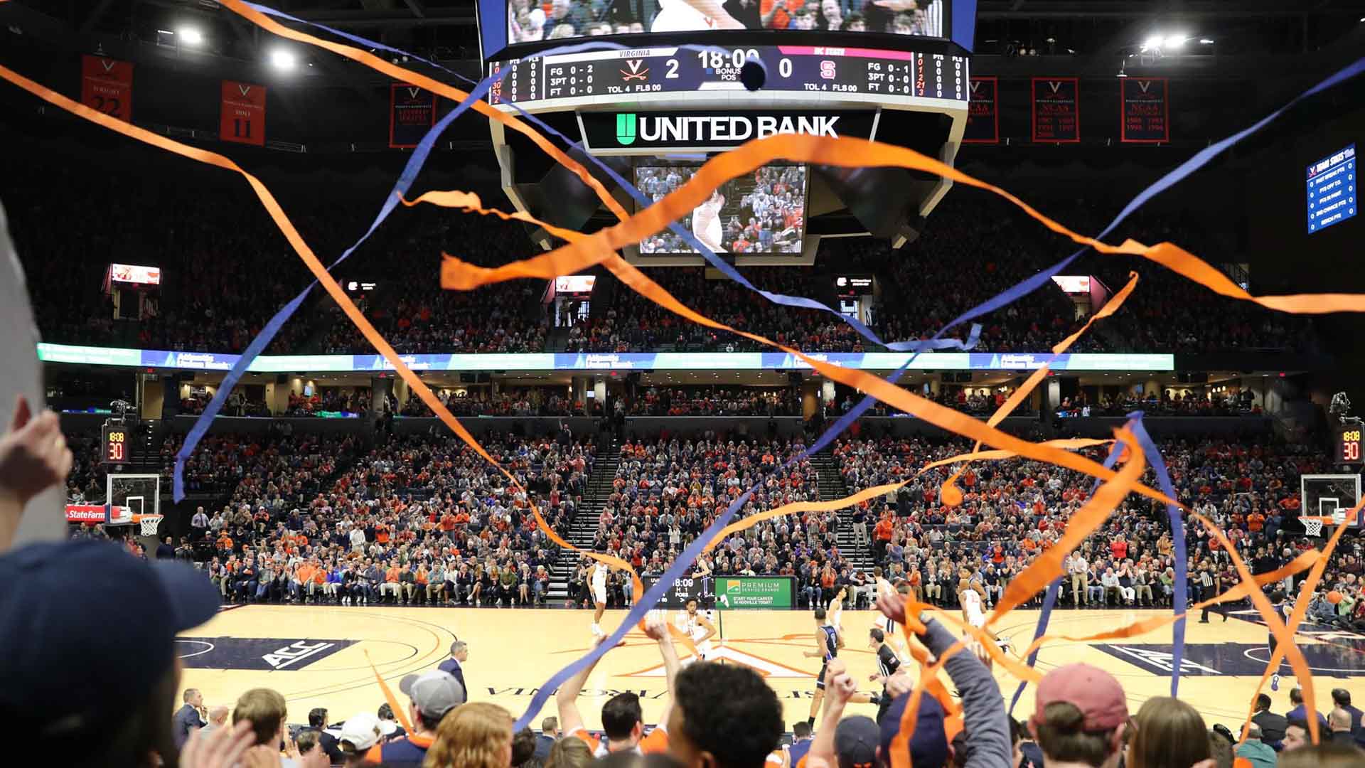 Blue and orange streamers being thrown during a basketball game