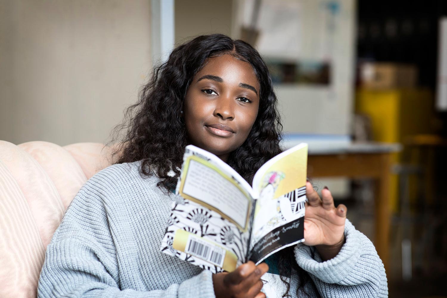 Uzo Njoku reading a book on a couch 