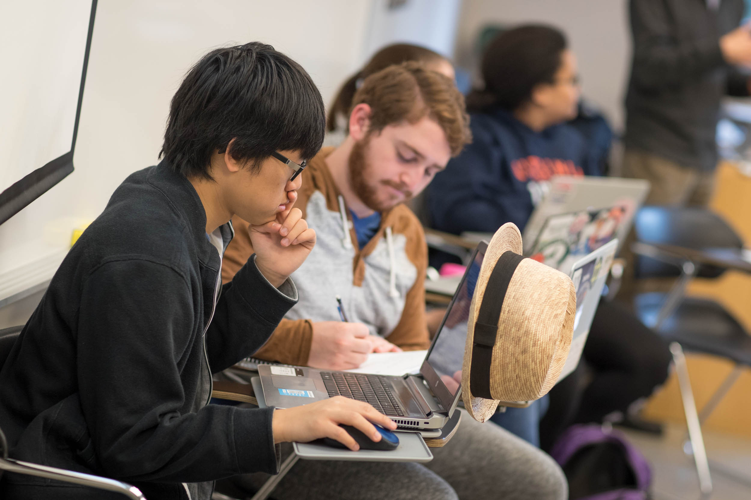 Thuy Vuong, seated in his class at UVA, is taking the course with his brother, Huan, who is a member of The Tribe. (Photo by Sanjay Suchak, University Communications)