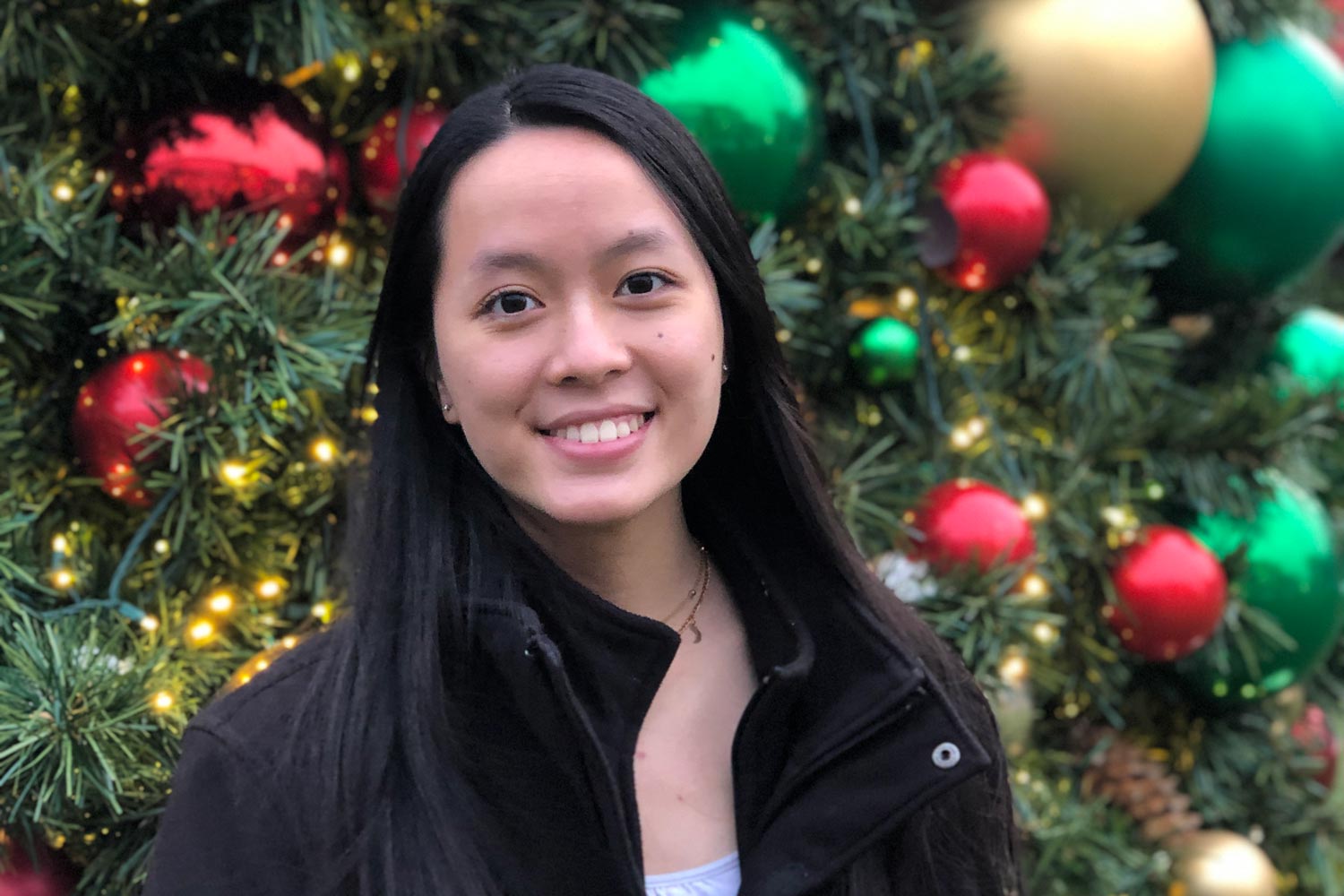 Cao-Dao standing in front of a Christmas tree for her headshot