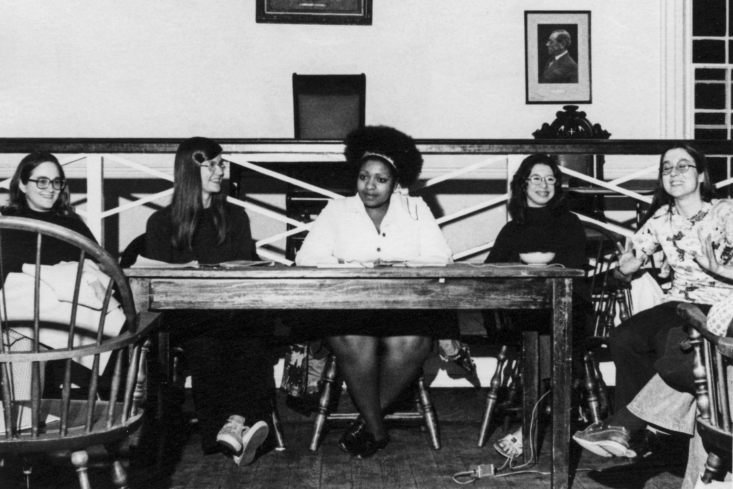 Black and white image of women sitting at a table having a discussion