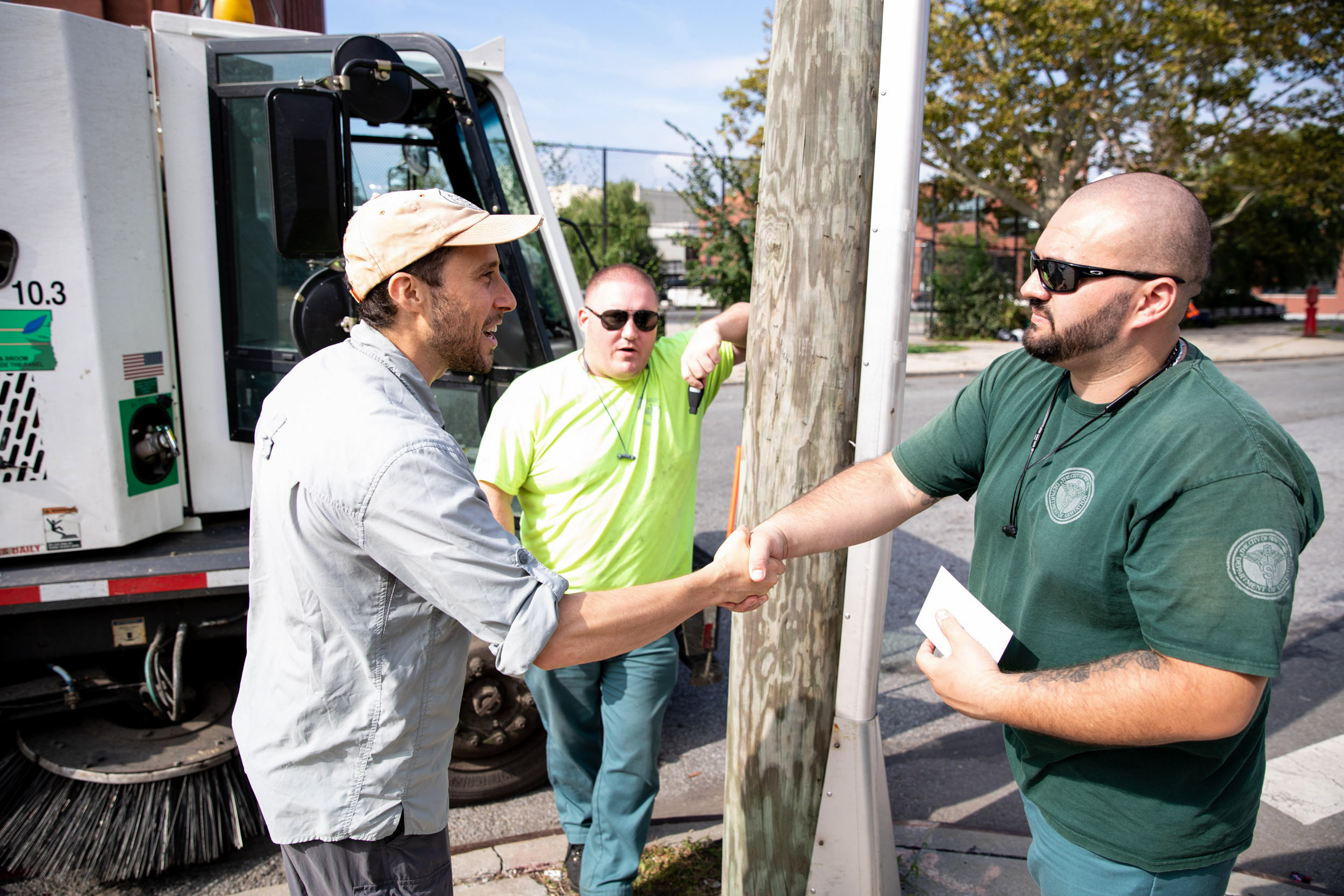 Green shaking hands of the sanitation workers in Redhook, Brooklyn. 
