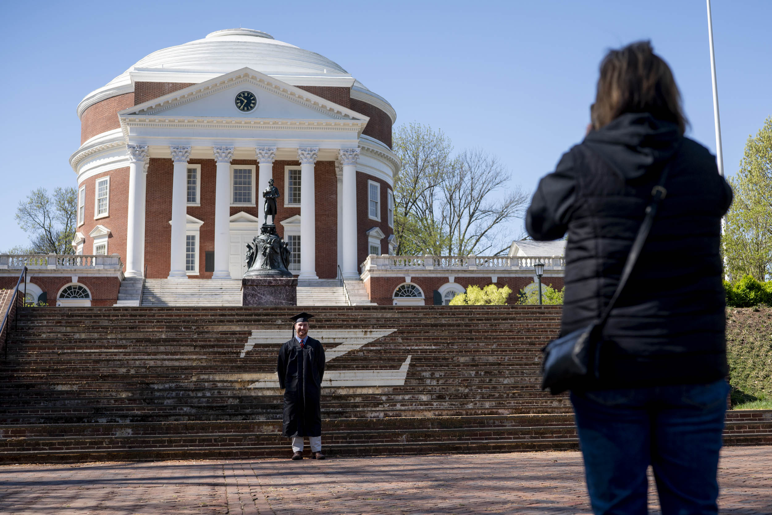 Mom taking a picture of her son as they stand in front of the Rotunda and Thomas Jeffersons statue