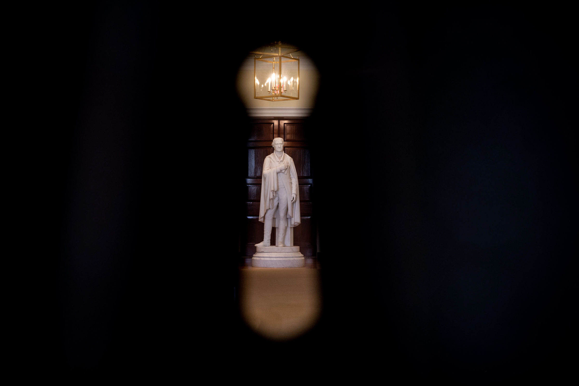 Thomas Jefferson statue seen through a keyhole in a door